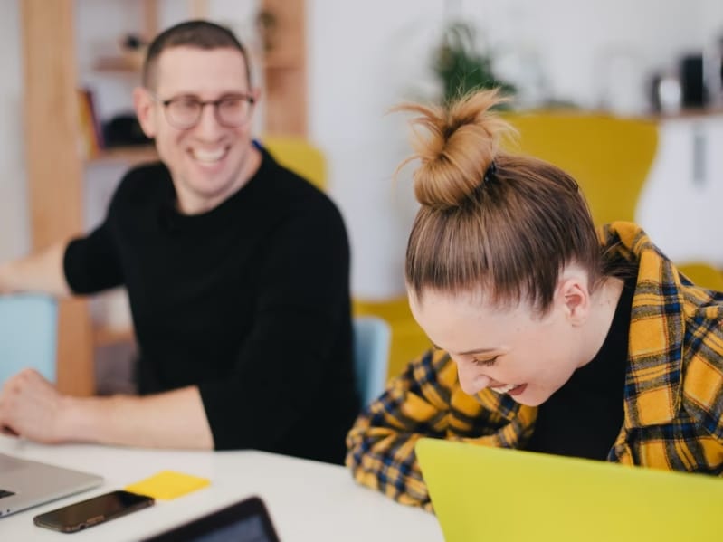 man and woman laughing at work