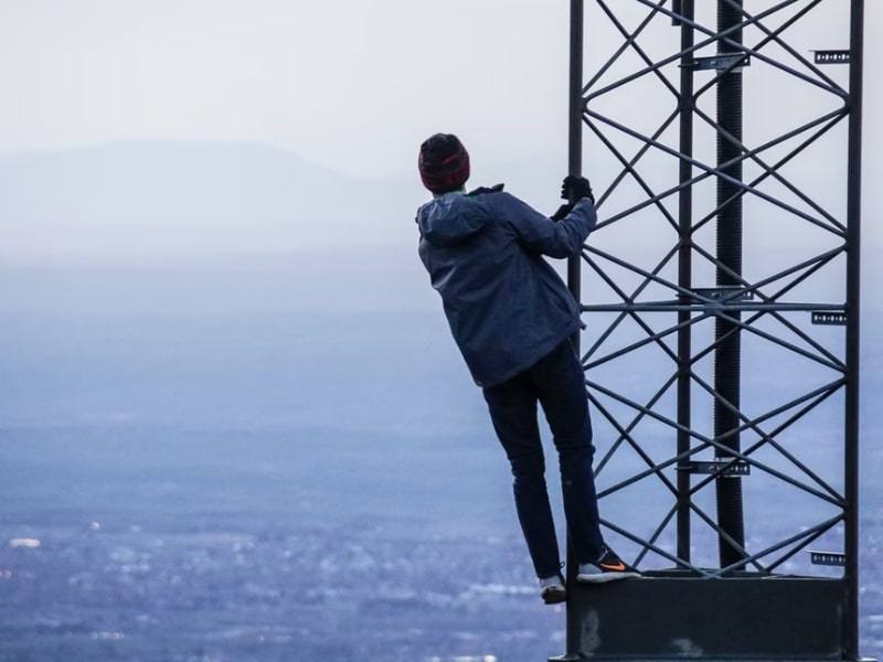 man climbing tower ocean