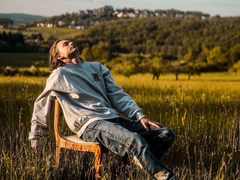 man relaxing on chair outdoors