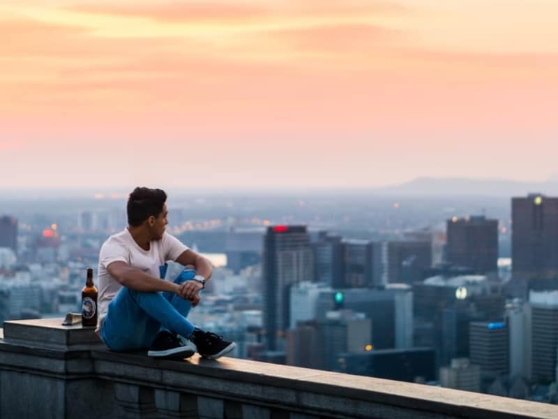 man sitting on balcony city view