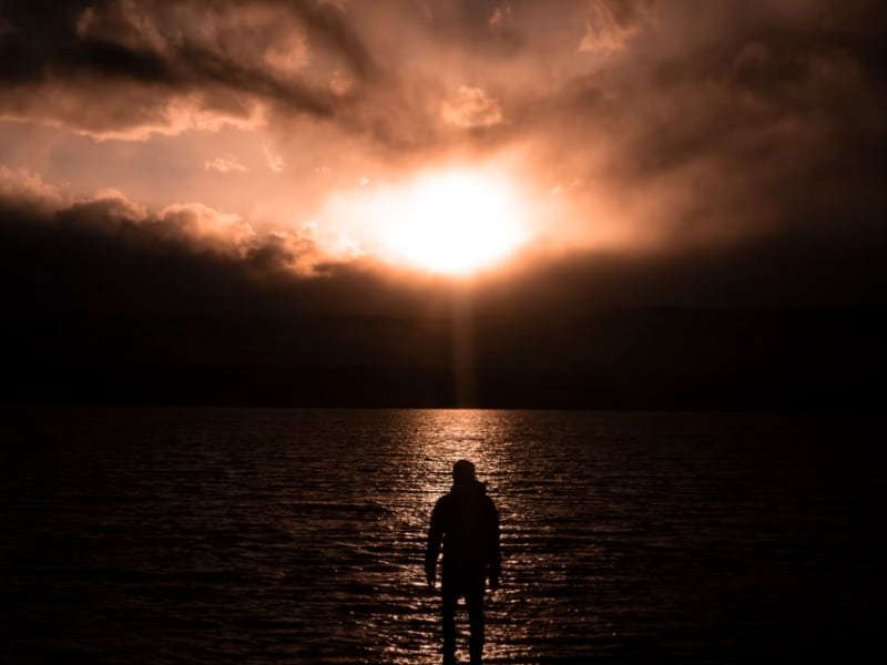 man standing in sun set light