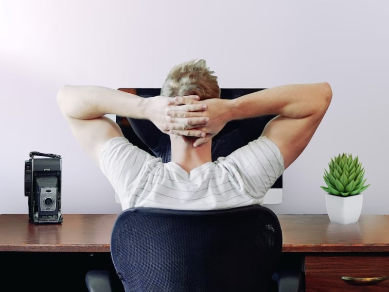 man thinking behind desk computer