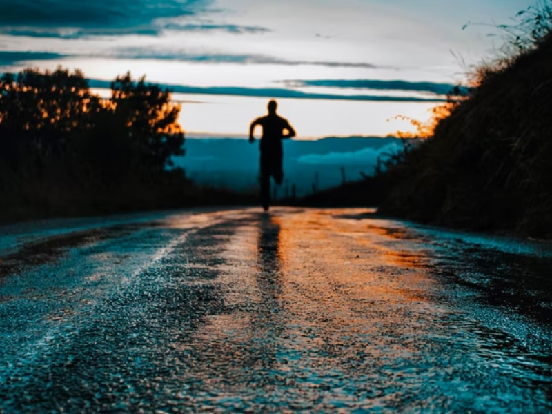 person running on road in rain