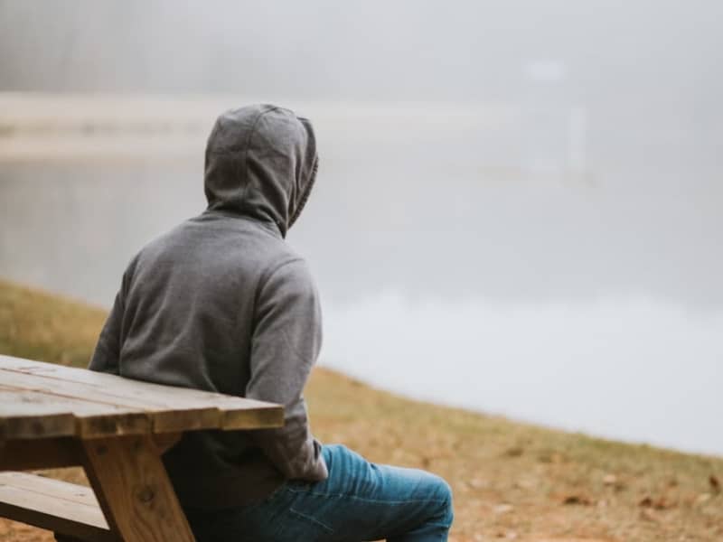 person sitting overlooking body of water