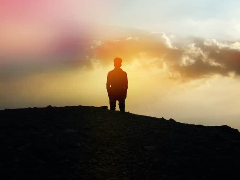 person standing under colorful sky