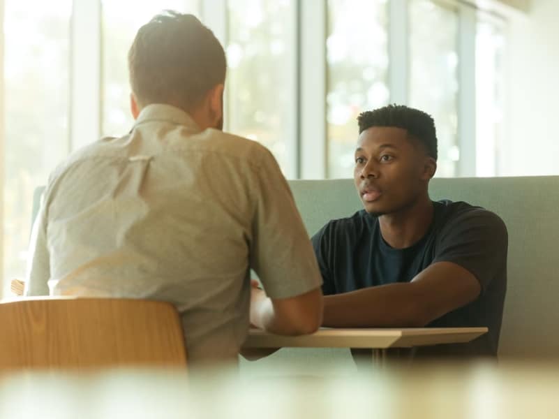 two men talking and listening