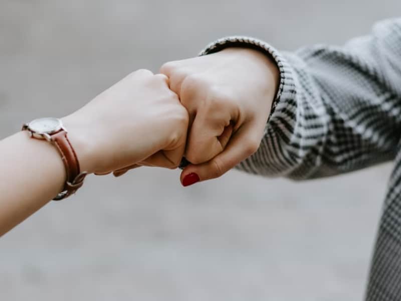 two persons fist bumping