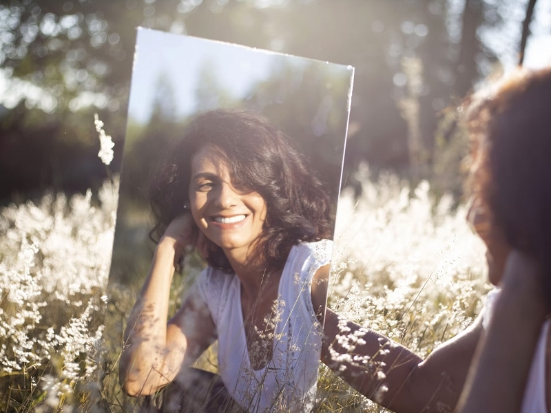 woman laughing at a mirror