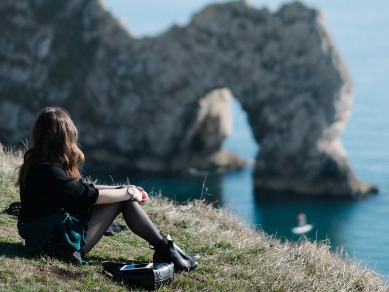 woman looking out to cliff ocean