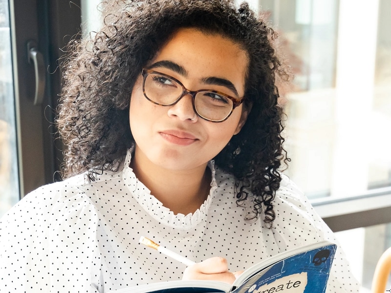 woman thinking while writing