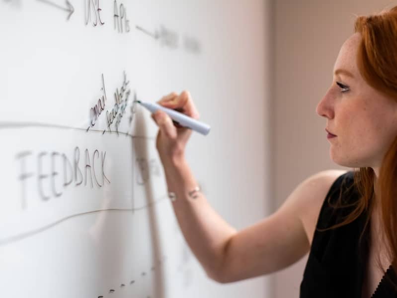 woman writing on whiteboard